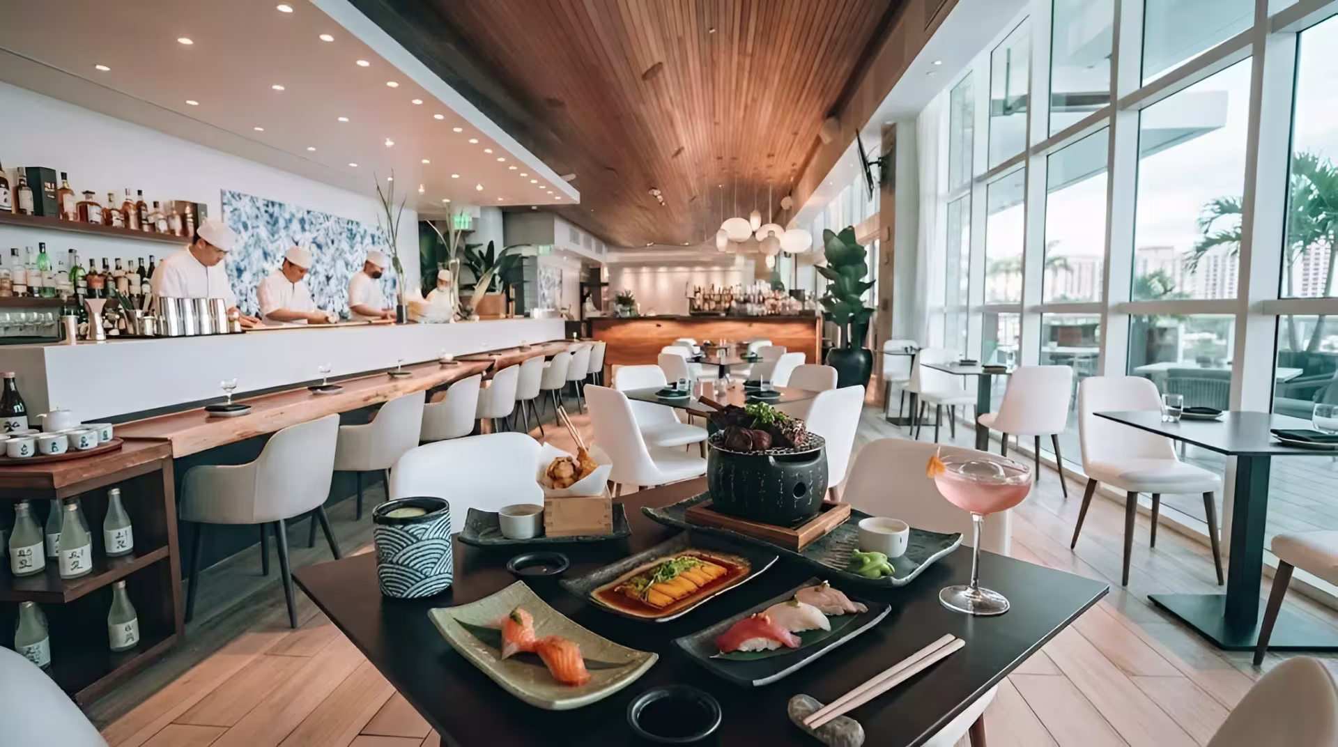 Upscale sushi bar interior with assorted Japanese fusion dishes and cocktails on a table