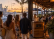 Group of friends arriving at a lively waterfront restaurant in Fort Lauderdale at sunset