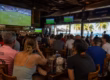 Soccer fans watching a FIFA World Cup match at a lively waterfront sports bar in Fort Lauderdale